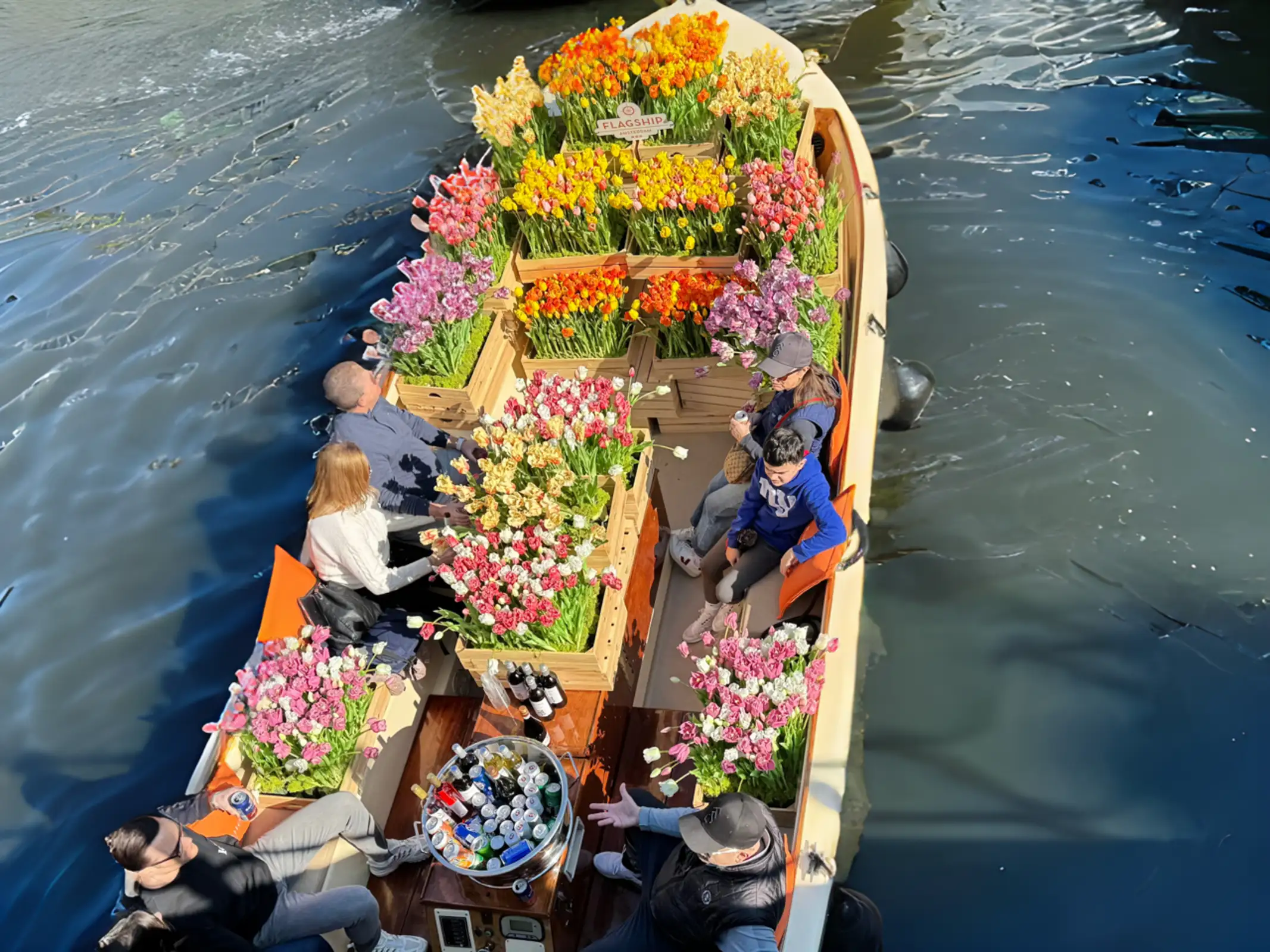 Tulip boat cruising through the Amsterdam canals with blooming tulips on board