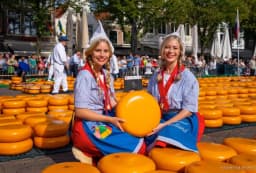 men walking with wheels of cheese